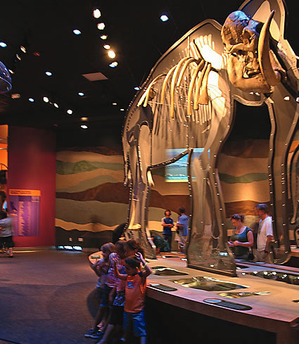 A mammoth exhibit with children standing in front of it