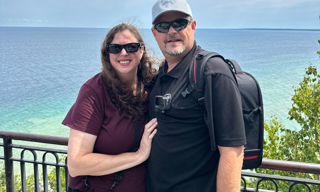 Jason and Julie standing in front of a waterfront scene