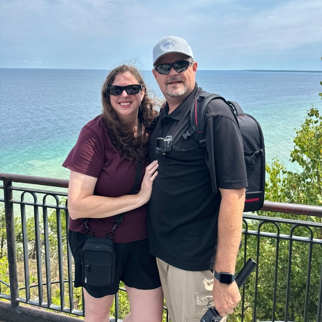 Jason and Julie standing in front of a waterfront scene