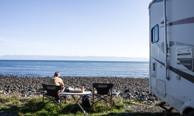 Ross is sitting, looking a the ocean, while their RV is parked at the small hamlet of Jordan River on Vancouver Island’s west coast.