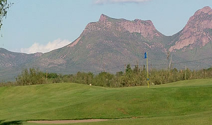 Golf green with mountains in background