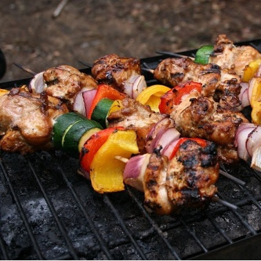 Photo of skewer with meat & red & green peppers.