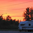 RV parked in a campsite with sunset in background