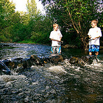 two boys fishing in a creek