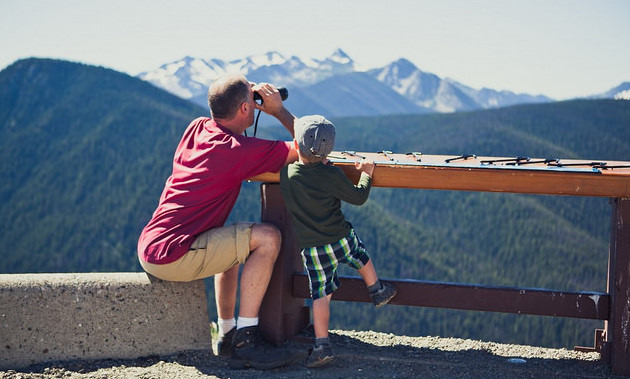 A father and sun looking through binoculars at a lookout at Manning Park.
