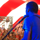 Musician plays in front of crowd under a tent