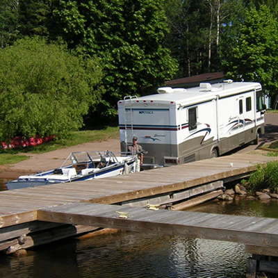 Picture of RV backing boat down a boat ramp. 