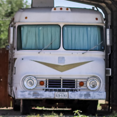 A motorhome with a 'V' design on the front, round headlights. 