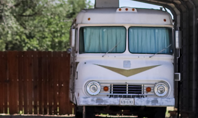 A motorhome with a 'V' design on the front, round headlights. 