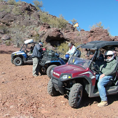 Picture of people standing with off-road vehicles. 
