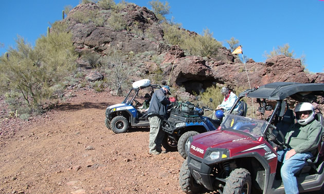 Picture of people standing with off-road vehicles. 