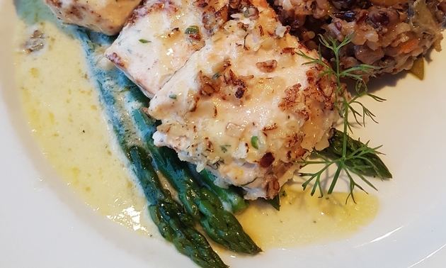 a fish dish with asparagus and other veggies on the side