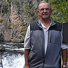 man standing beside a waterfall