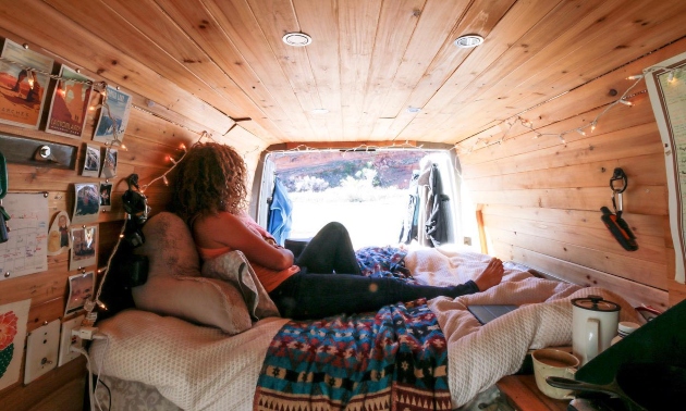 Kaya sitting in her van looking out the back window.