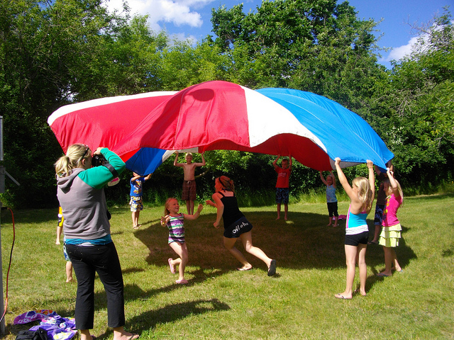 kids playing with a colourful parachute