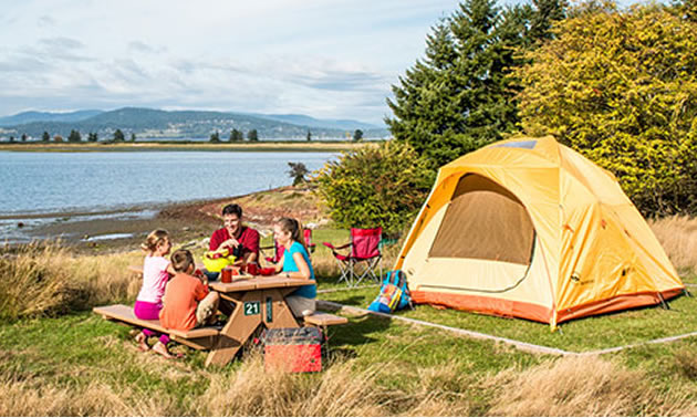 Family camping along a lakeshore. 