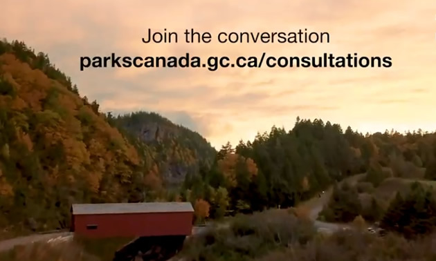 Video still from Parks Canada website, showing covered bridge and forest. 