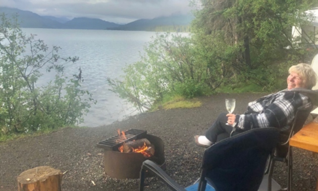 Phyllis sitting on a camping chair looking over the ocean