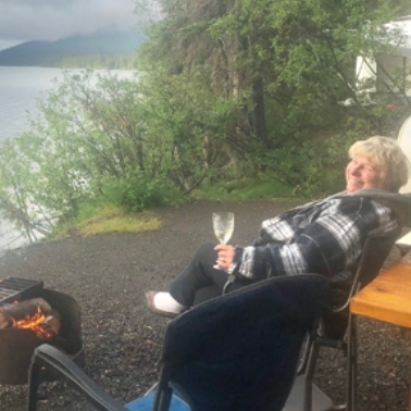 Phyllis sitting on a camping chair looking over the ocean