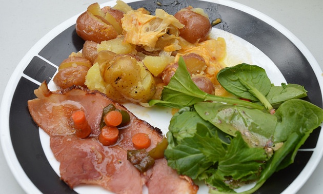 The plated meal of ham with apricot ginger glaze, potatoes with cheese and a fresh green salad.