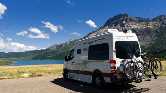 A Pleasure-Way van, parked in front of a lake. 