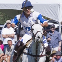 2 riders, one in yellow, the other in blue, playing polo at the Empire Polo Club in Indio, California.