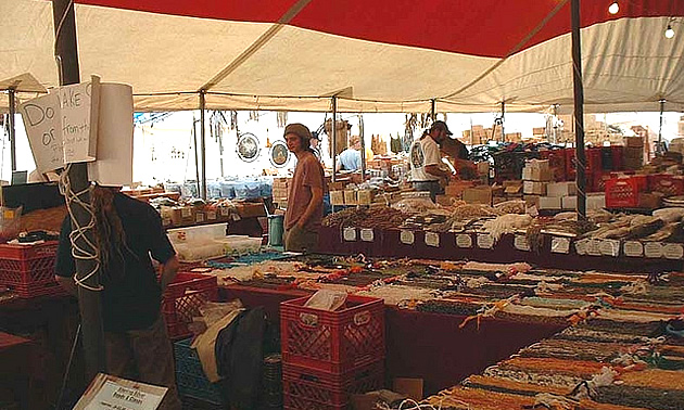 man standing behind a counter selling crafts at the Quartzsite show