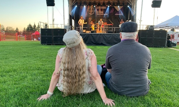 A couple sitting in front of a music stage