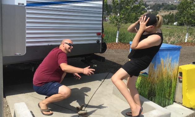 Two people in front of an RV