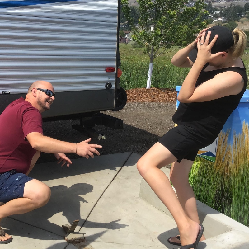 Two people in front of an RV