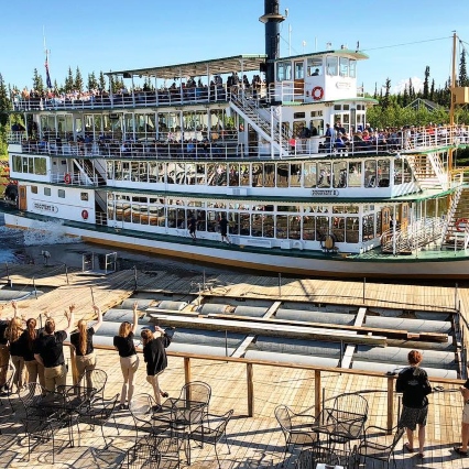 The Discovery III riverboat with people waiting on the shore to get on