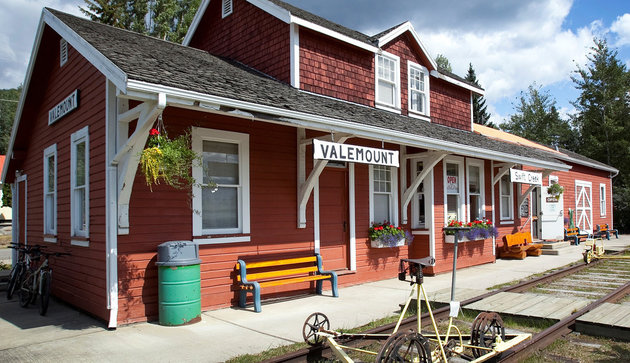 The front of the Valemount Museum is covered in red boards and has a bench on the front porch. It used to be the town's first train station.