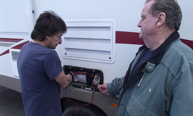 Runners RV service technician Lloyd Panchuk checks voltage on a furnace as Service Manager Tom Gilgan look on.