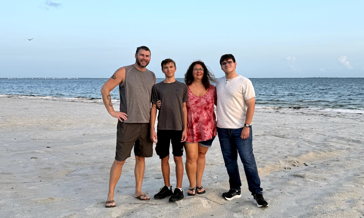 The Clayton family standing on the beach