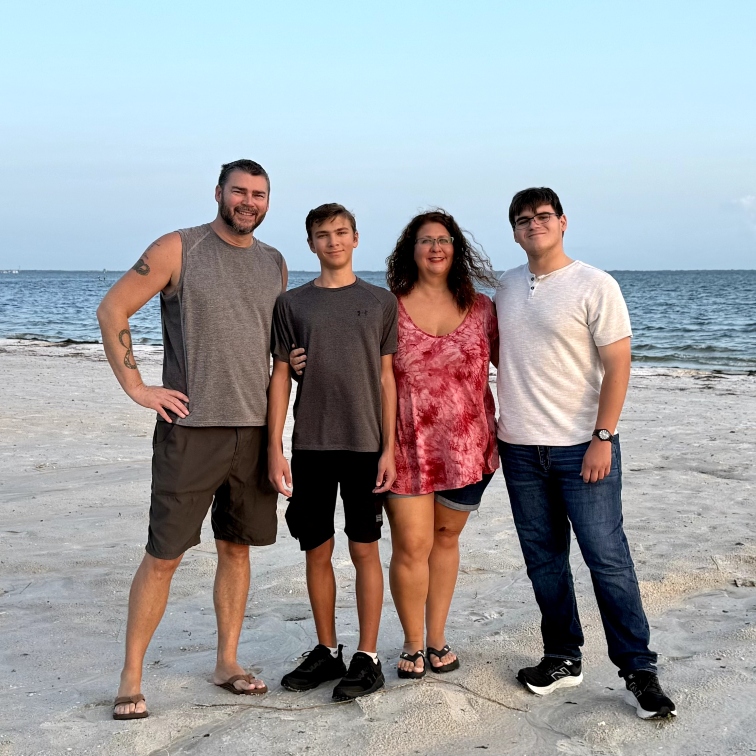 The Clayton family standing on the beach