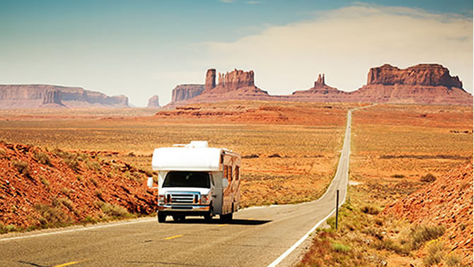 Picture of RV travelling down desert road. 