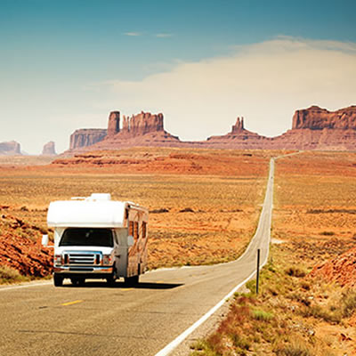 Picture of RV travelling down desert road. 