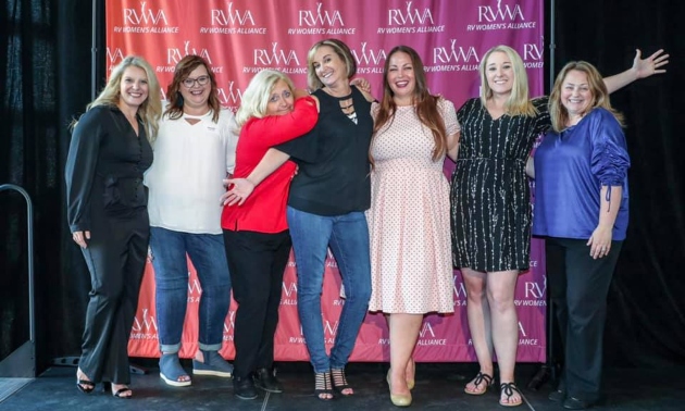 RVWA members standing against a background with their logo on it