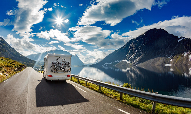 RV driving along a road with sunny skies