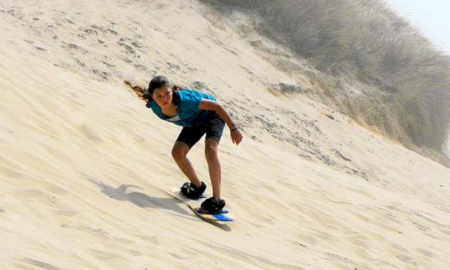 A young women sandboarding. 