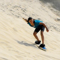 A young women sandboarding. 