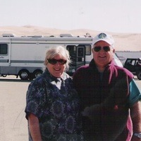 Carol and Don McDowall standing in front of their RV.