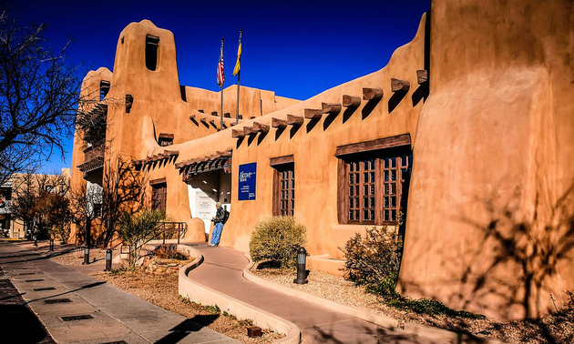 An adobe building in Santa Fe is silhouetted against a brilliant blue sky.