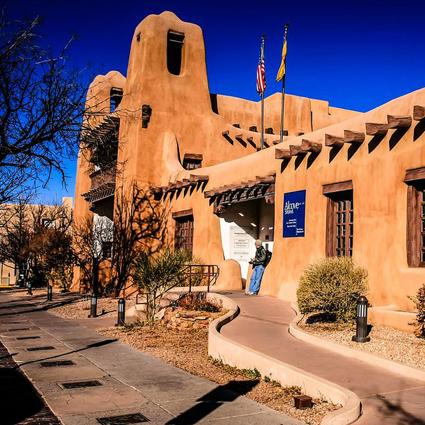 An adobe building in Santa Fe is silhouetted against a brilliant blue sky.