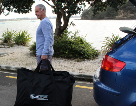 Picture of man holding storage bag with Scout boat in it. 