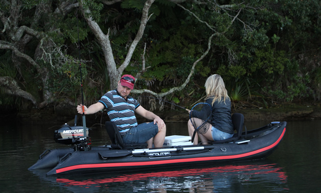 Picture of Scout boat in water, with two people sitting in boat. 