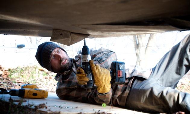 James Bryen replaces metal panelling underneath the Silver Streak after repairing a plumbing leak. 