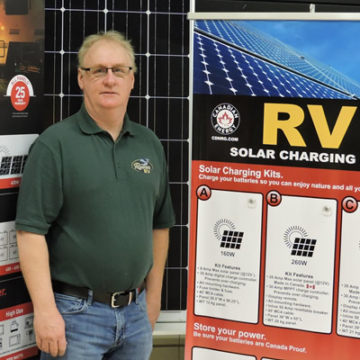 The author is standing in front of an RV solar power display. 