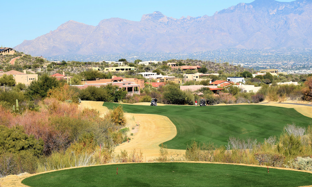 A golf course green with mountains in the background in Tucson, Arizona