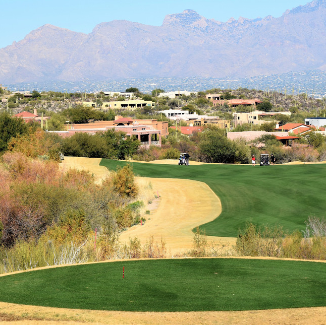 A golf course green with mountains in the background in Tucson, Arizona